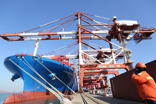 A port employee directs the cargo loading of a COSCO ship in Qingdao, Shandong province. (Photo by Zhang Jingang/For China Daily) A port employee directs the cargo loading of a COSCO ship in Qingdao, Shandong province. (Photo by Zhang Jingang/For China Daily)