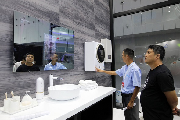 Visitors look at a smart mirror, which can monitor people's skin conditions, at the smart home products center of leading Chinese home appliance maker Midea Group in Foshan, South China's Guangdong province. (Photo/China Daily) Visitors look at a smart mirror, which can monitor people's skin conditions, at the smart home products center of leading Chinese home appliance maker Midea Group in Foshan, South China's Guangdong province. (Photo/China Daily)