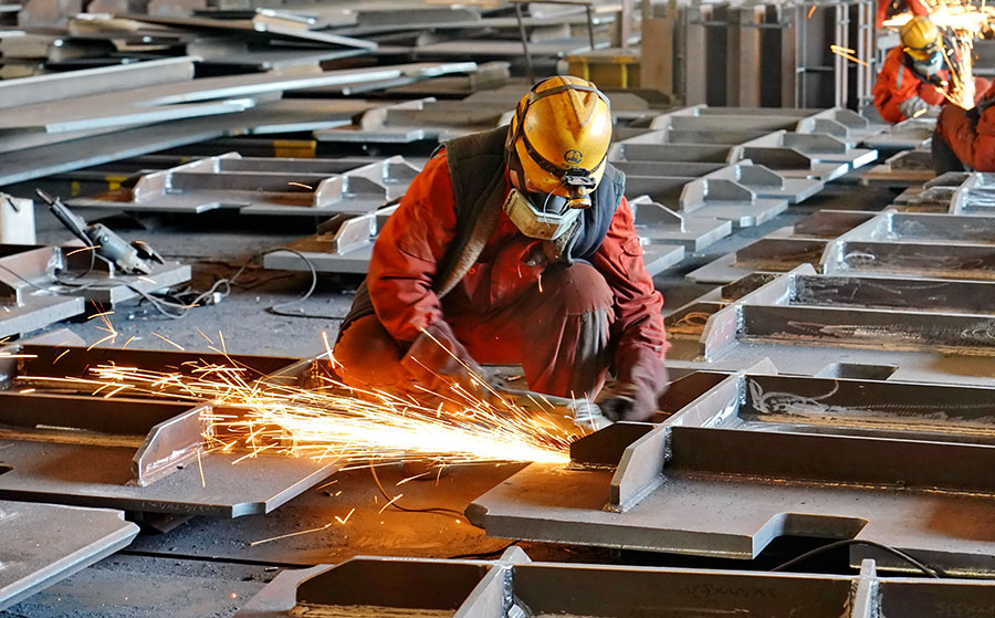 Employees of China Railway Shanhaiguan Bridge Group Co, based in Qinhuangdao, Hebei province, solder components used for building bridges. (Photo/Xinhua)