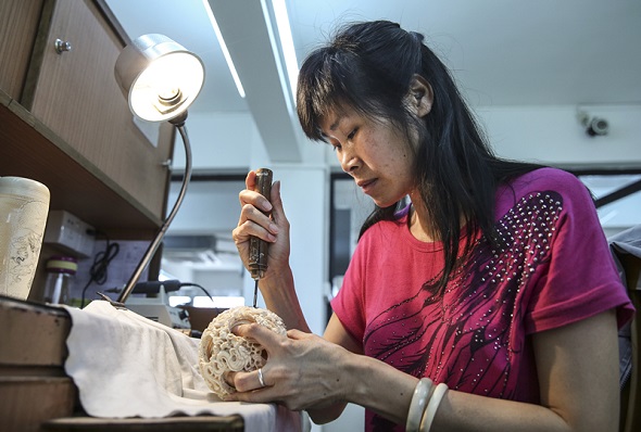 Qiu Yuying, an ivory carver from Guangdong province, displays her skills by making an ivory ball in 2017. (Zou Hong/China Daily) Qiu Yuying, an ivory carver from Guangdong province, displays her skills by making an ivory ball in 2017. (Zou Hong/China Daily)