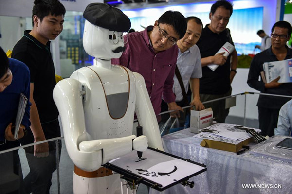 People watch a robot painting demonstration during the 19th China Hi-tech Fair in Shenzhen, south China's Guangdong Province, Nov. 16, 2017. Over 3,000 exhibitors participated in the hi-tech fair displaying a lot of robot and artificial intelligence projects. (Xinhua/Mao Siqian)