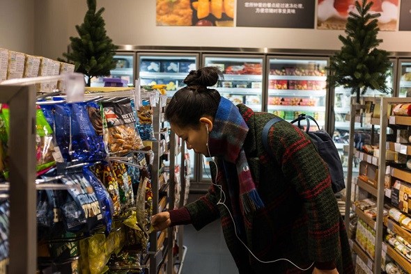 A customer picks British snacks at a supermarket in Beijing. (Photo provided to China Daily) A customer picks British snacks at a supermarket in Beijing. (Photo provided to China Daily)
