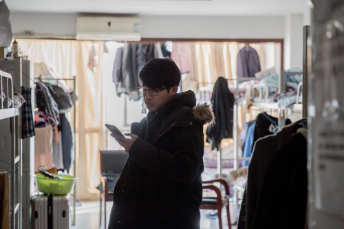 A tenant in a Beijing apartment checks his smartphone for leads to cheaper accommodation. (Photo provided to China Daily) A tenant in a Beijing apartment checks his smartphone for leads to cheaper accommodation. (Photo provided to China Daily)