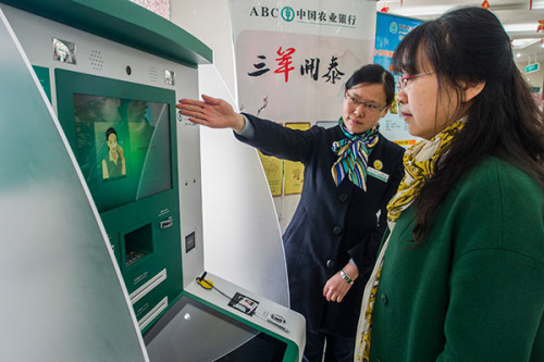 An employee of Agricultural Bank of China Ltd helps a client at an outlet of the bank in Zhenjiang, Jiangsu Province. (Photo by Feng Jiangjiang/for China Daily) An employee of Agricultural Bank of China Ltd helps a client at an outlet of the bank in Zhenjiang, Jiangsu Province. (Photo by Feng Jiangjiang/for China Daily)