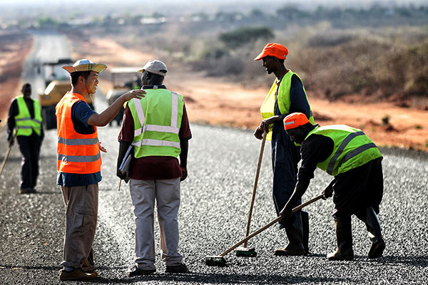 Construction workers level the surface of a road in Kenya's Marsabit district being built by China Wu Yi Co Ltd. (Photo/Xinhua) Construction workers level the surface of a road in Kenya's Marsabit district being built by China Wu Yi Co Ltd. (Photo/Xinhua)