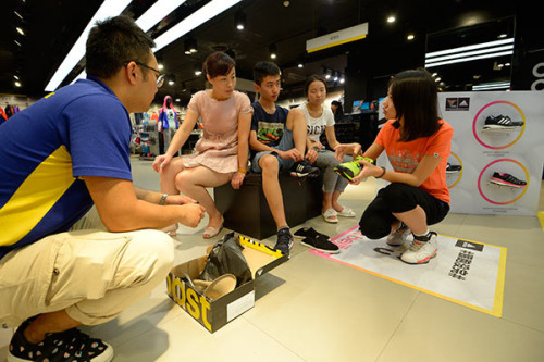 A customer tries on an Adidas shoe at the company's store in Datong, Shanxi Province. (Photo by Hu Yuanjia/for China Daily) A customer tries on an Adidas shoe at the company's store in Datong, Shanxi Province. (Photo by Hu Yuanjia/for China Daily)