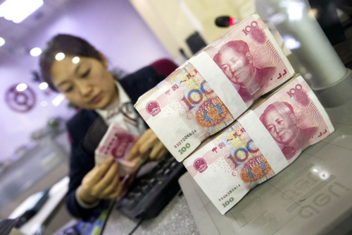 A cashier at a bank in Taiyuan, Shanxi province, counts renminbi notes. (Photo/China News Service) A cashier at a bank in Taiyuan, Shanxi province, counts renminbi notes. (Photo/China News Service)