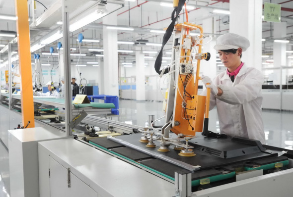An employee puts finishing touches to a television set in a facility of Foxconn in Guiyang, Guizhou province. (Photo provided to China Daily)