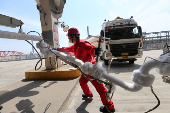 An employee shifts the LNG pipeline after filling the transport vehicle at the CNPC LNG center in Jiangsu province. (Photo for China Daily/Xu Congjun) An employee shifts the LNG pipeline after filling the transport vehicle at the CNPC LNG center in Jiangsu province. (Photo for China Daily/Xu Congjun)
