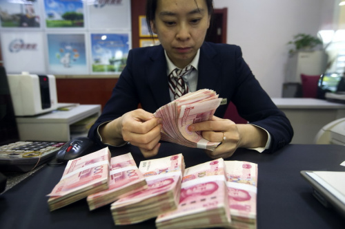 A clerk counts cash at a bank outlet in Taiyuan, Shanxi Province. (Photo by Zhang Yun/China News Service) A clerk counts cash at a bank outlet in Taiyuan, Shanxi Province. (Photo by Zhang Yun/China News Service)