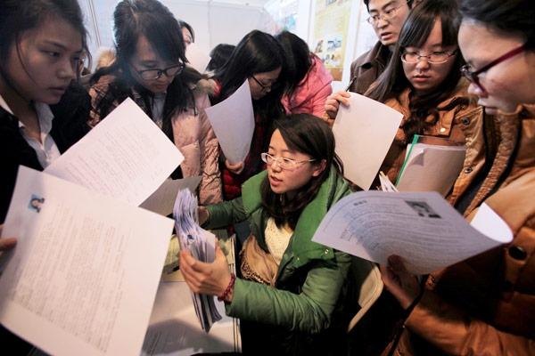 A recruiter is surrounded by employment seekers at a job fair. More than 70 percent of workers wanted to change their jobs in pursuit of a better salary in the first quarter of 2015, according to a recent survey from 51job.com, a leading recruitment website in China. (File photo: WANG JING / CHINA DAILY]