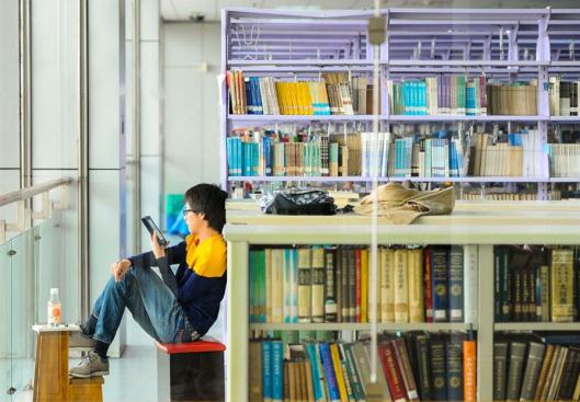 A young man reads novels on a Kindle at a library in Shanghai. The rise of e-reading is challenging the traditional way of reading books. (File photo/ Xinhua) A young man reads novels on a Kindle at a library in Shanghai. The rise of e-reading is challenging the traditional way of reading books. (File photo/ Xinhua)