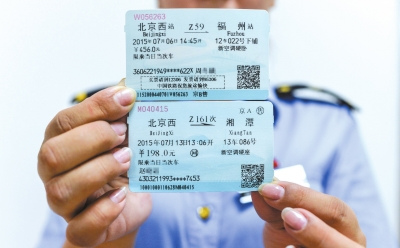 A railway policeman holds a new train ticket (up) and an old one (down). (Photo/Chinanews.com) A railway policeman holds a new train ticket (up) and an old one (down). (Photo/Chinanews.com)