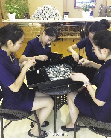 Jewelry store staff in Anhui province calculate coins afforded by a young man in Fuyang city. (Photo/Chinanews.com) Jewelry store staff in Anhui province calculate coins afforded by a young man in Fuyang city. (Photo/Chinanews.com)