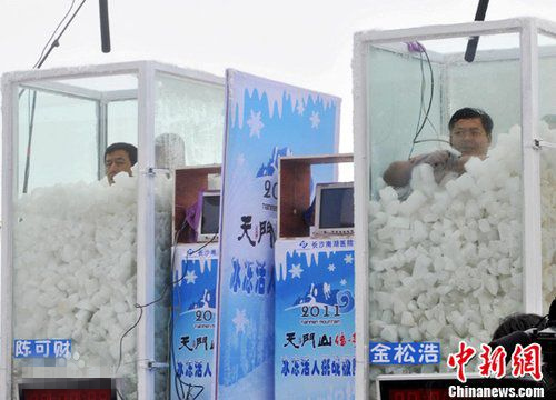 Jin Songhao (R) sits in a box of ice cubes. (Photo/China News Service) Jin Songhao (R) sits in a box of ice cubes. (Photo/China News Service)