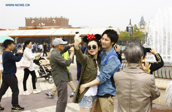 Tourists pose for a selfie outside the Disney Resort in Shanghai, May 7, 2016. (Photo/Xinhua) Tourists pose for a selfie outside the Disney Resort in Shanghai, May 7, 2016. (Photo/Xinhua)