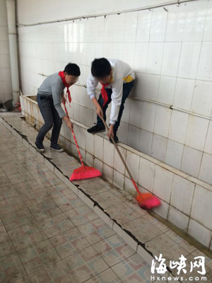 Two students from an elementary school in eastern Fujian Province clean public toilets Two students from an elementary school in eastern Fujian Province clean public toilets