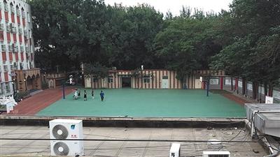Young men play basketball on the playground of Baiyunlu campus of the No. 2 Experimental Elementary School in Beijing. (Photo/Beijing News)