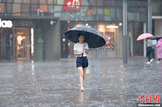 A woman holding an umbrella walks in the rain in Beijing, July 20, 2016. (Photo/Chinanews.com) A woman holding an umbrella walks in the rain in Beijing, July 20, 2016. (Photo/Chinanews.com)