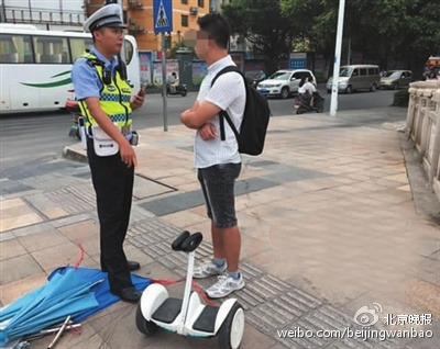 A policeman stops a young self-balancing scooter rider in Beijing. (Photo/Beijing Evening News) A policeman stops a young self-balancing scooter rider in Beijing. (Photo/Beijing Evening News)