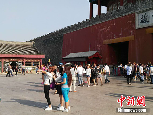 Visitors use a selfie-stick to take photos outside of the Palace Museum in Beijing. (File photo/Chinanews.com) Visitors use a selfie-stick to take photos outside of the Palace Museum in Beijing. (File photo/Chinanews.com)
