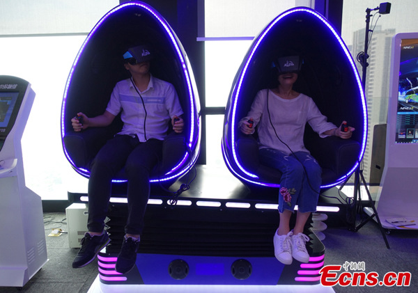 Two media representatives attending the China-Russia Internet Media Forum experience a 9D virtual reality cinema series product manufactured by NINED VR in Tianhe district, Guangzhou, South China’s Guangdong Province, Oct. 28, 2016. (Photo: Ecns.cn/Wang Fan) Two media representatives attending the China-Russia Internet Media Forum experience a 9D virtual reality cinema series product manufactured by NINED VR in Tianhe district, Guangzhou, South China’s Guangdong Province, Oct. 28, 2016. (Photo: Ecns.cn/Wang Fan)