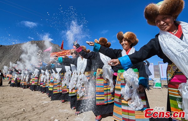 Villagers in festival costume scatter barley flour which is a tradition of giving best wishes. (Photo: China News Service/He Penglei) Villagers in festival costume scatter barley flour which is a tradition of giving best wishes. (Photo: China News Service/He Penglei)