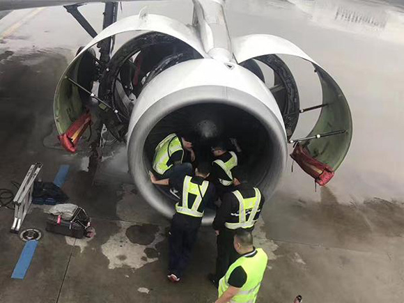 Airport staff check the engine of China Southern Airlines flight CZ380, into which an elderly woman tossed nine coins. (Photo from the Web) Airport staff check the engine of China Southern Airlines flight CZ380, into which an elderly woman tossed nine coins. (Photo from the Web)