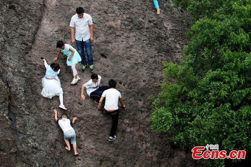 Unruly tourists take short cut on cliff in Hangzhou city(1/3)