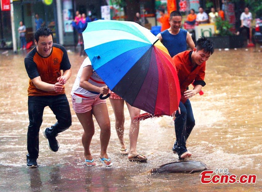 People catch fish on flooded street in South China city (1/4)