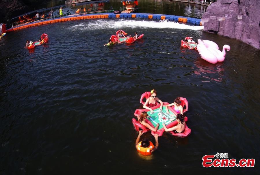 Playing mahjong in cool water to beat heat (1/9)