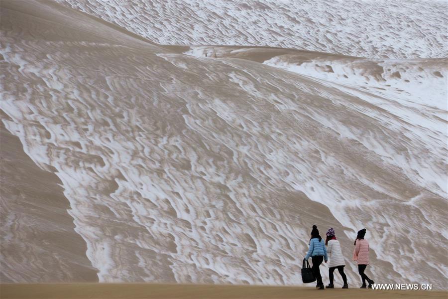 Tourists enjoy snow scenery in Dunhuang's desert(1/3)