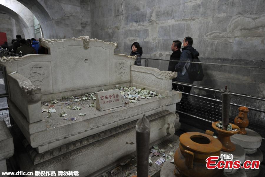 Tourists offer money at Ming tomb for luck (1/3)