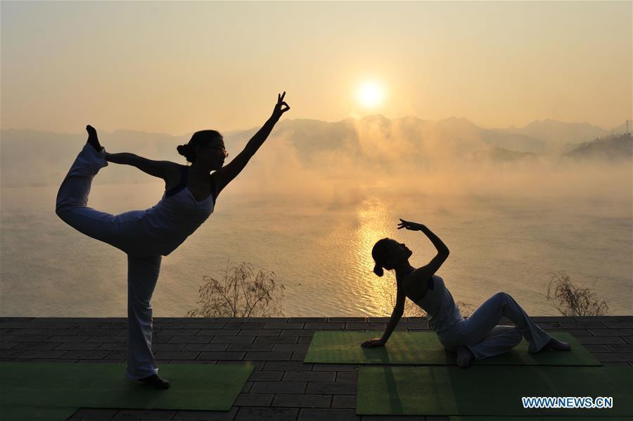 Yoga fans practice in sunset glow in Hubei(1/6)