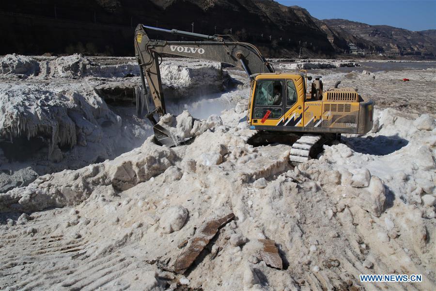 Excavators clean away piled ice at Hukou Waterfall(1/4)