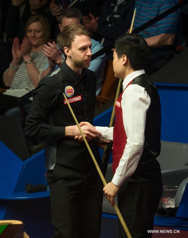 Ding Junhui (R) of China shakes hands with Judd Trump of England after their second round match at Snooker World Championship 2016 at the Crucible Theatre in Sheffield, England, on April 25, 2016. Ding won 13-10. (Xinhua/Jon Buckle)