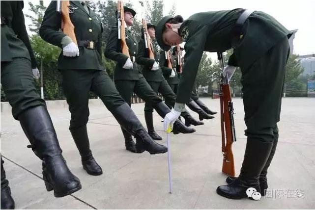 An instructor measuring the height of a female soldier\'s leg during straight-leg march training on July 29, 2016, ahead of Chinese Army Day on August 1. (Photo/CRIENGLISH.com)