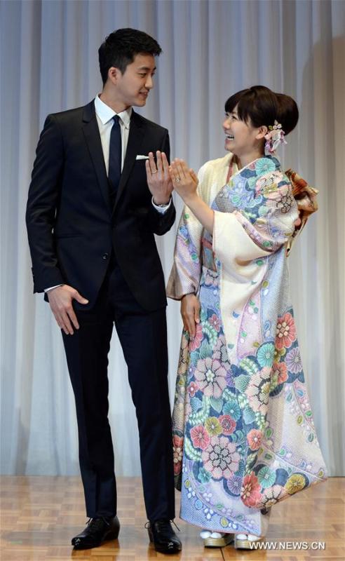 Japanese table tennis player Ai Fukuhara (R) and table tennis player Chiang Hung-Chieh of Chinese Taipei show off their marriage rings while posing for photographers during a press conference to announce their marriage in Tokyo, Japan, Sept. 21, 2016. (Photo/Xinhua)