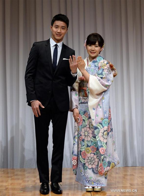Japanese table tennis player Ai Fukuhara (R) and table tennis player Chiang Hung-Chieh of Chinese Taipei show off their marriage rings while posing for photographers during a press conference to announce their marriage in Tokyo, Japan, Sept. 21, 2016. (Photo/Xinhua)
