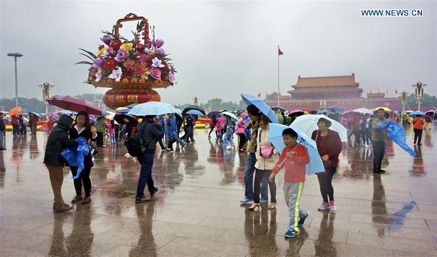 Rain doesn't dampen travelers' holiday spirit in Beijing(1/2)
