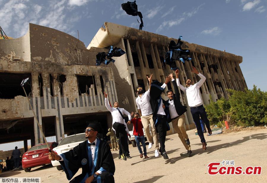 Libya students mark graduation in front of damaged building(1/5)