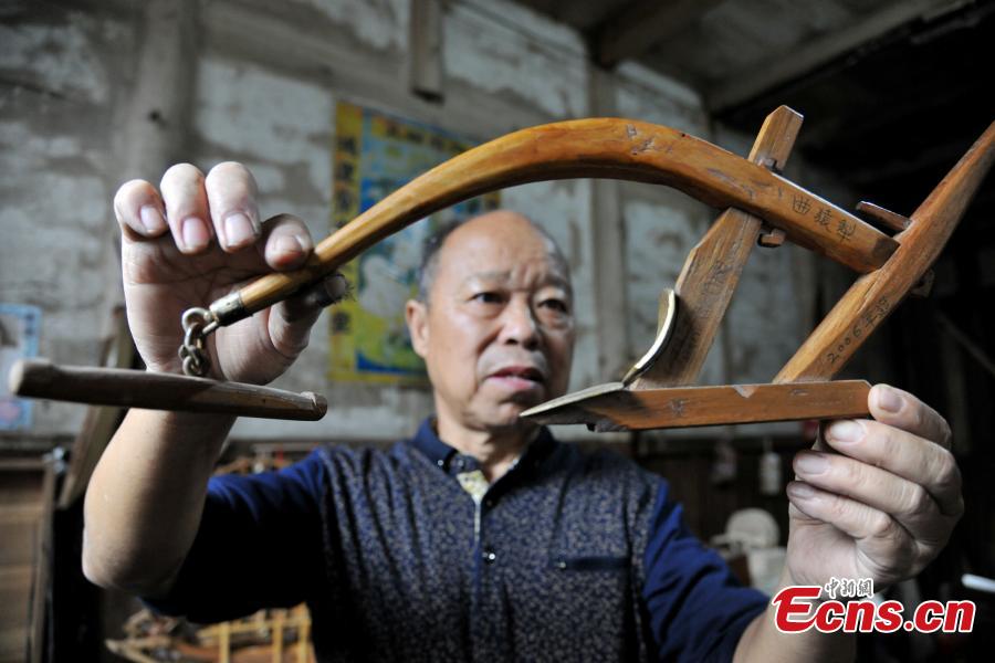 Elderly carpenter fascinated with miniature farm tools (1/9)