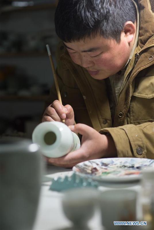 Artist Xiang Zhengyi creates traditional literati painting on a porcelain at the workshop in Jingdezhen, east China\'s Jiangxi Province, Dec. 23, 2016. (Xinhua/Weng Xinyang)