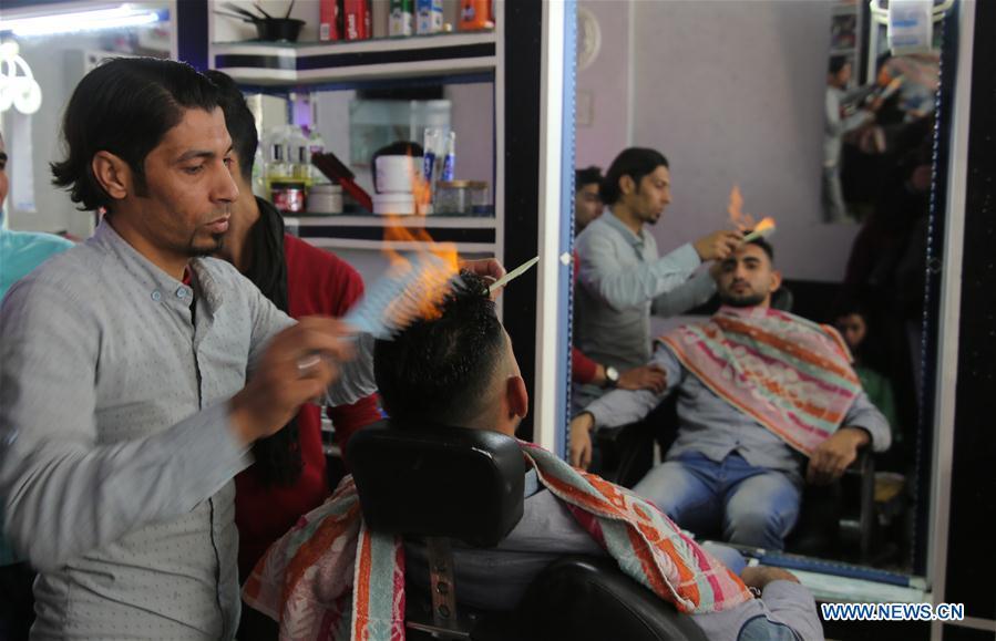 Palestinian barber uses fire in hair-straightening technique in salon (1/1)
