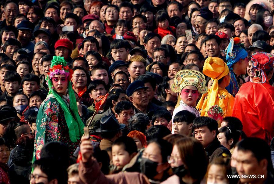 
People watch performance of Shehuo at a temple fair in Junxian County, central China\'s Henan Province, Feb. 12, 2017. Shehuo is a folk entertainment popular in China. It can be traced back to ancient rituals to worship the earth, which people believe could bring good harvests and fortunes in return. (Xinhua/Li An)