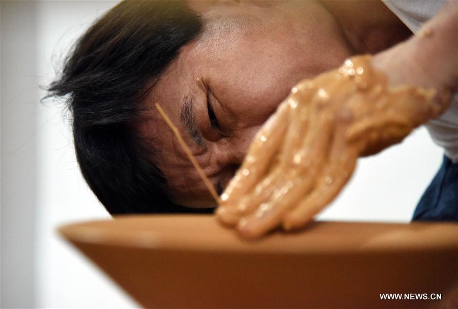 Intangible cultural heritage inheritor Feng Shaoxing makes an unburned earthenware at a workshop at Jingdezhen, east China\'s Jiangxi Province, June 26, 2017. Jingdezhen has a history of porcelain-making that dates back more than 1,000 years. In the late Ming Dynasty (1368-1644), it was not only the home of imperial kilns, but also a center for porcelain exports. (Xinhua/Song Zhenping)