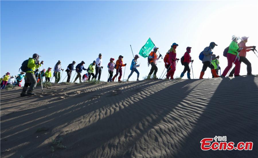 Hikers traverse the Gobi Desert near Zhangye City, Northwest China’s Gansu Province on July 16, 2017. Despite air temperatures of 38 degrees centigrade and ground temperatures of 50 degrees centigrade, 307 people from 11 provinces and cities undertook a 10-km hike across the searing sand. (Photo: China News Service/Wang Jiang)