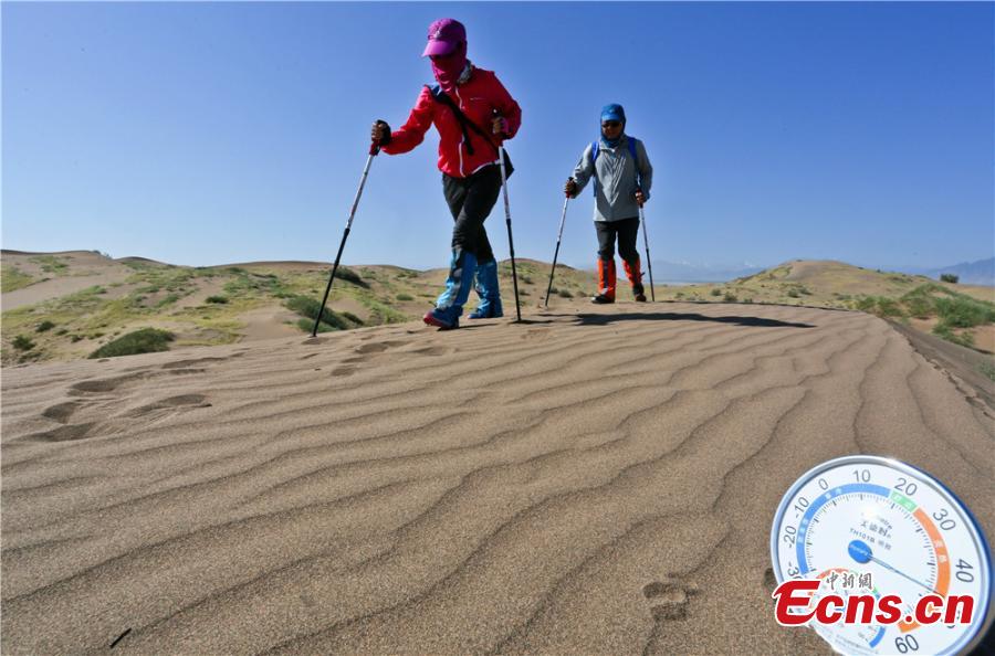 Hikers traverse the Gobi Desert near Zhangye City, Northwest China’s Gansu Province on July 16, 2017. Despite air temperatures of 38 degrees centigrade and ground temperatures of 50 degrees centigrade, 307 people from 11 provinces and cities undertook a 10-km hike across the searing sand. (Photo: China News Service/Wang Jiang)