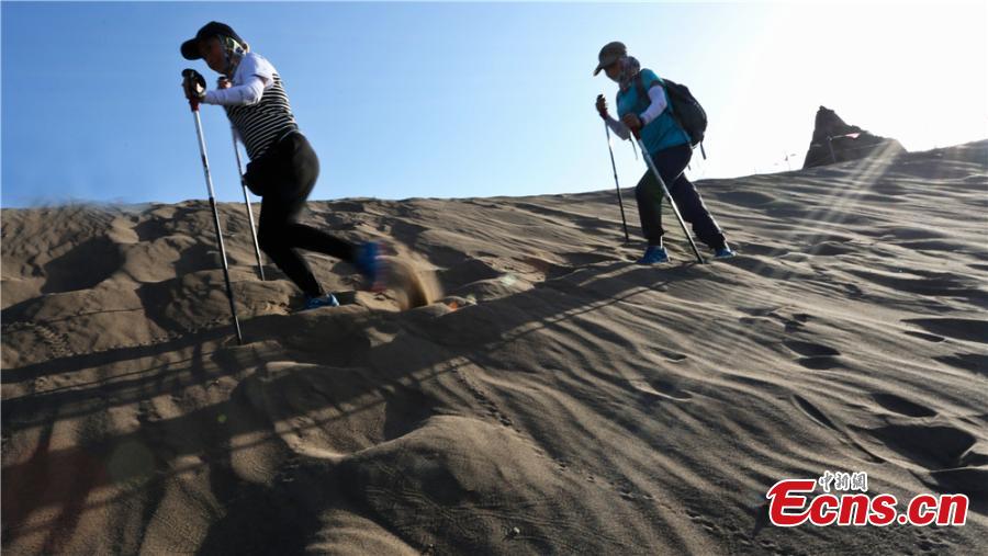 Hikers traverse the Gobi Desert near Zhangye City, Northwest China’s Gansu Province on July 16, 2017. Despite air temperatures of 38 degrees centigrade and ground temperatures of 50 degrees centigrade, 307 people from 11 provinces and cities undertook a 10-km hike across the searing sand. (Photo: China News Service/Wang Jiang)