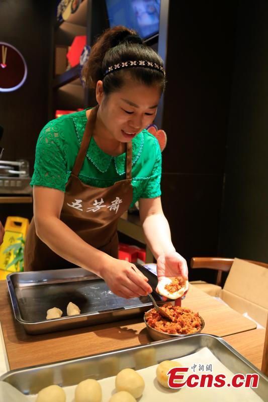 A cook prepares mooncakes stuffed with crayfish at a restaurant in Hangzhou City, the capital of East China’s Zhejiang Province, Sept. 29, 2017. The restaurant is experimenting with using novel ingredients in their mooncakes, a must-have delicacy for the Mid-Autumn Festival, to boost business. (Photo: China News Service/Wang Yuan)